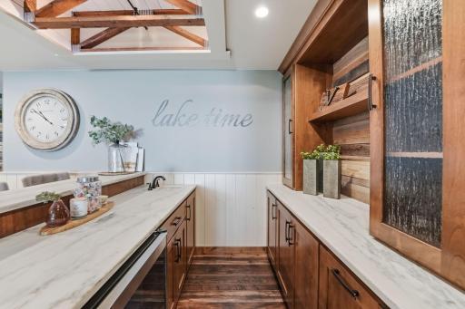 The details just in this picture depict the energy this homeowner put into play. Marble tops, glass doors, canned lighting, wood backed bottle run, ship lap ceilings under the exposed truss, and a gorgeous floor to bring it all together.