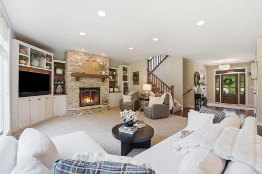 Main living room with fireplace, media center, and built in cabinets.