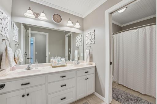 Double sinks provide ample counter space and convenience for multiple users in this shared upper level bath.