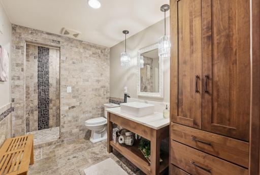 Lower level bathroom features storage, vessel sink vanity, fantastic lighting and a walk in shower with tile design that is going to feel upgraded for years to come.