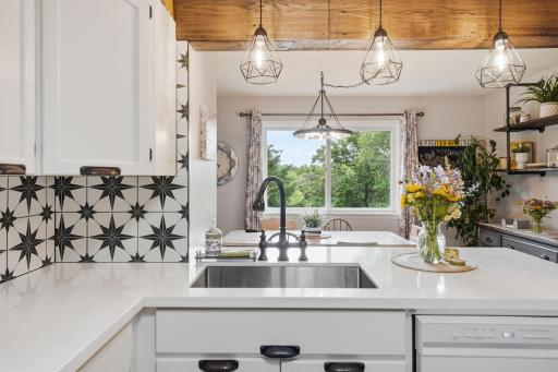 Kitchen sink overlooks the bright dining space. Kitchen was renovated in 2023- included counters, backsplash, sink & stove. Dishwasher was new June 2026.