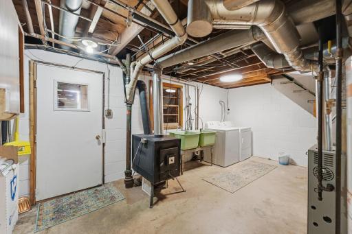 Lower level laundry room with a utility sink. Mechanicals hosted here include the wood stove, and a Furnace and Humidifier that were updated in July of 2022.