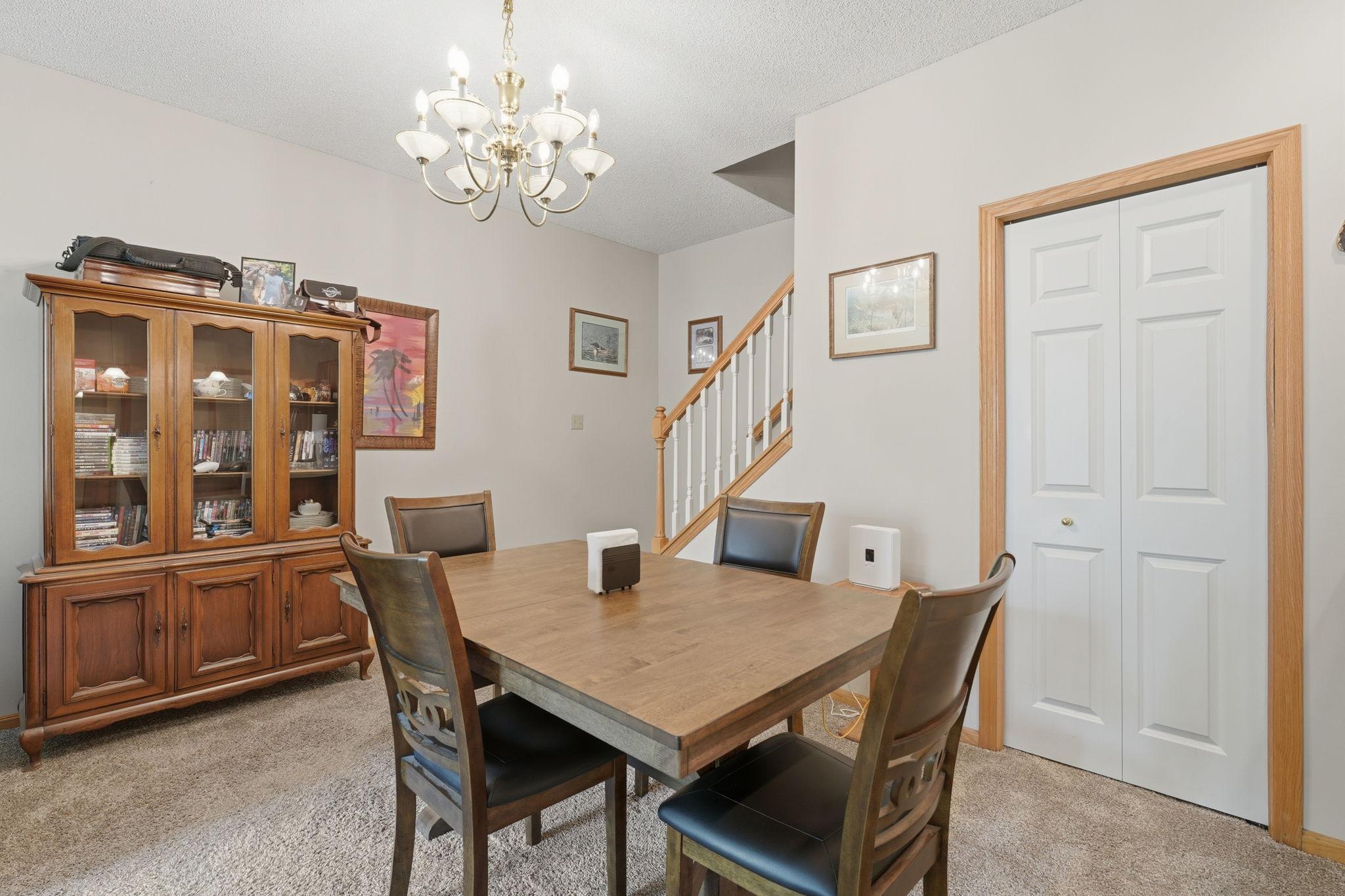 Dining tucked into living room with storage under the stairs