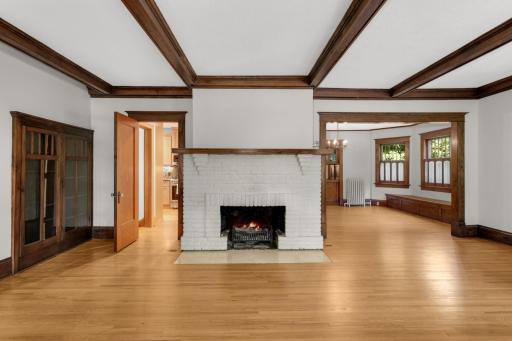 Wood burning fireplace in main floor unit living room - door to the left leads to the back stairway and kitchen - to the right is a glimpse of the formal dining room