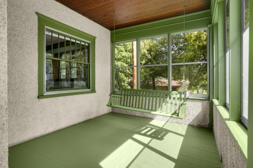 Large front porch with entrances to the main floor and upper unit (photo shows window to the living room of main unit)