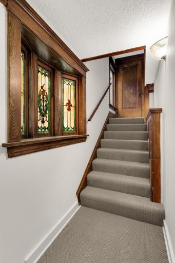 Photo of stained glass windows and stairway leading to sencond floor unit