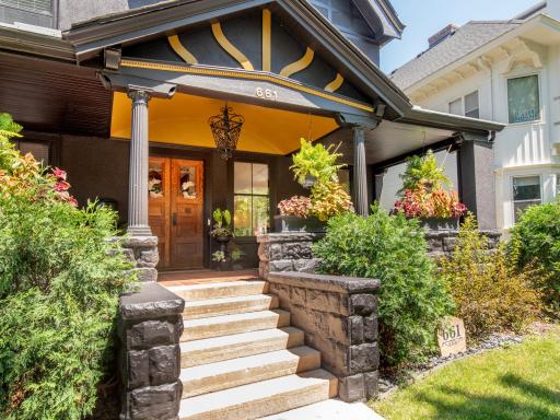 Classic Tudor architecture, rich stonework, and a welcoming front porch define this exceptional home