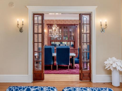 Glass doors lead to an elegant formal dining room, a timeless setting for life's most memorable celebrations