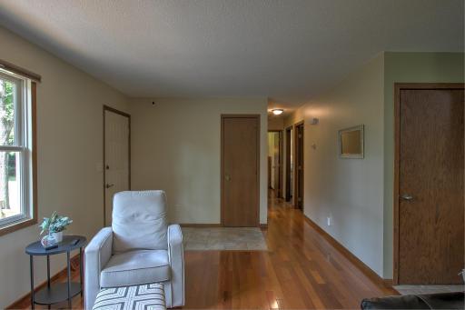 View from living room to front door and hallway that leads to full bath and all 3 bedrooms. Door to the right leads to basement
