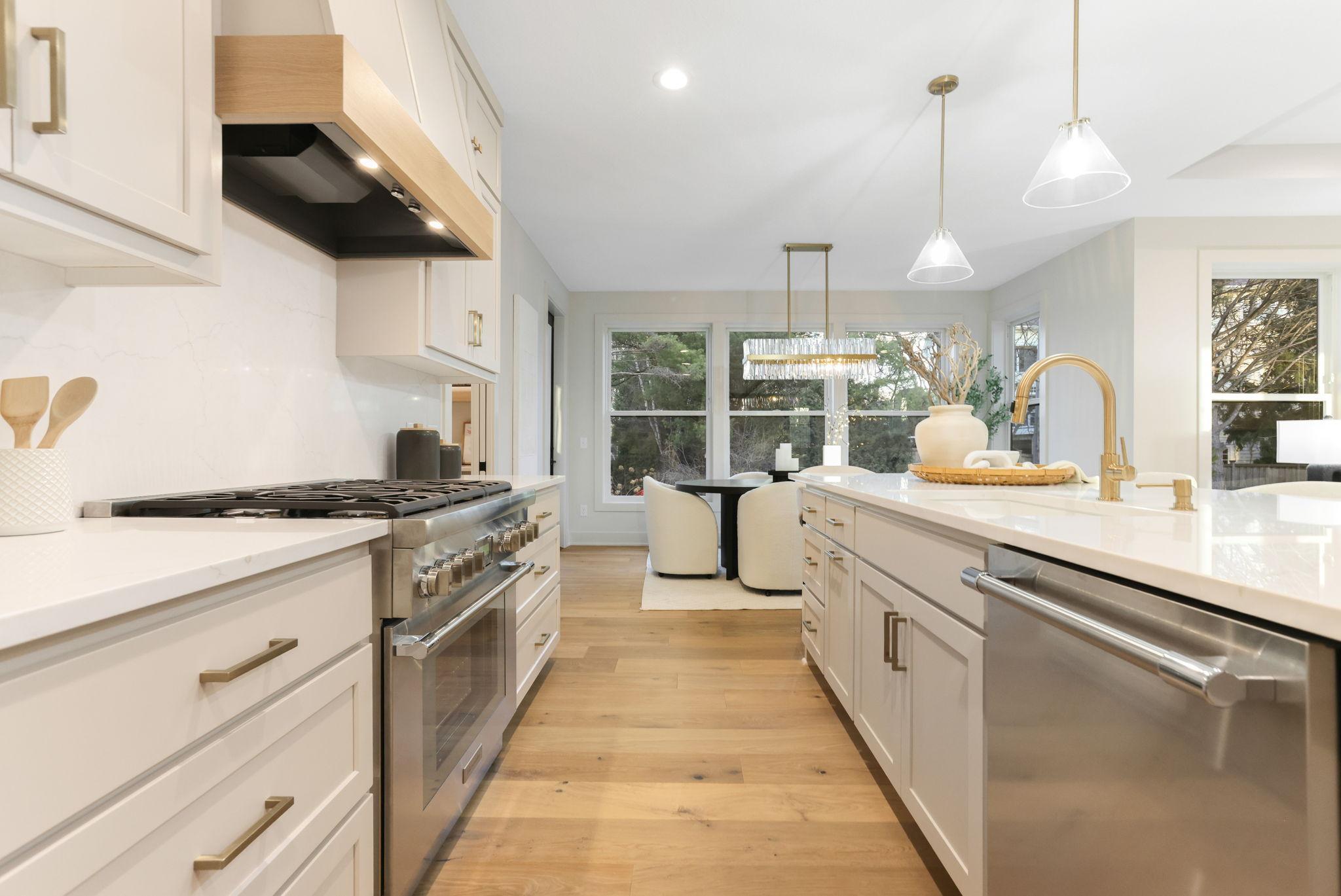 The kitchen features premium Thermador appliances, an oversized center island, custom soft-close cabinetry