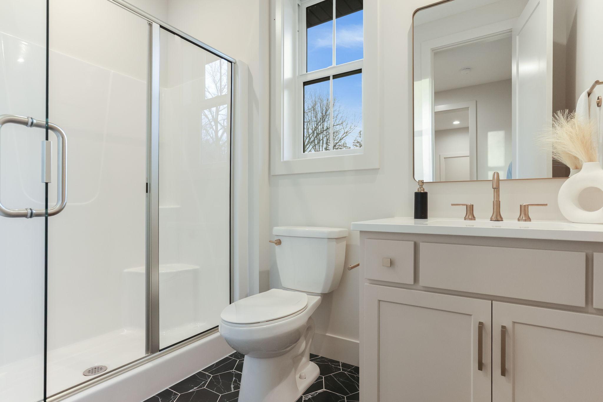 The main-level ¾ bathroom combines modern design with practical elegance for guests or everyday use.