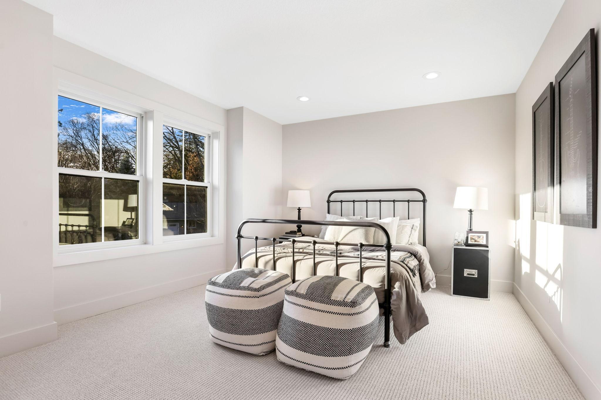 This spacious bedroom features a large walk-in closet and shares a stylish Jack and Jill full bathroom, complete with dual vanities and modern finishes.
