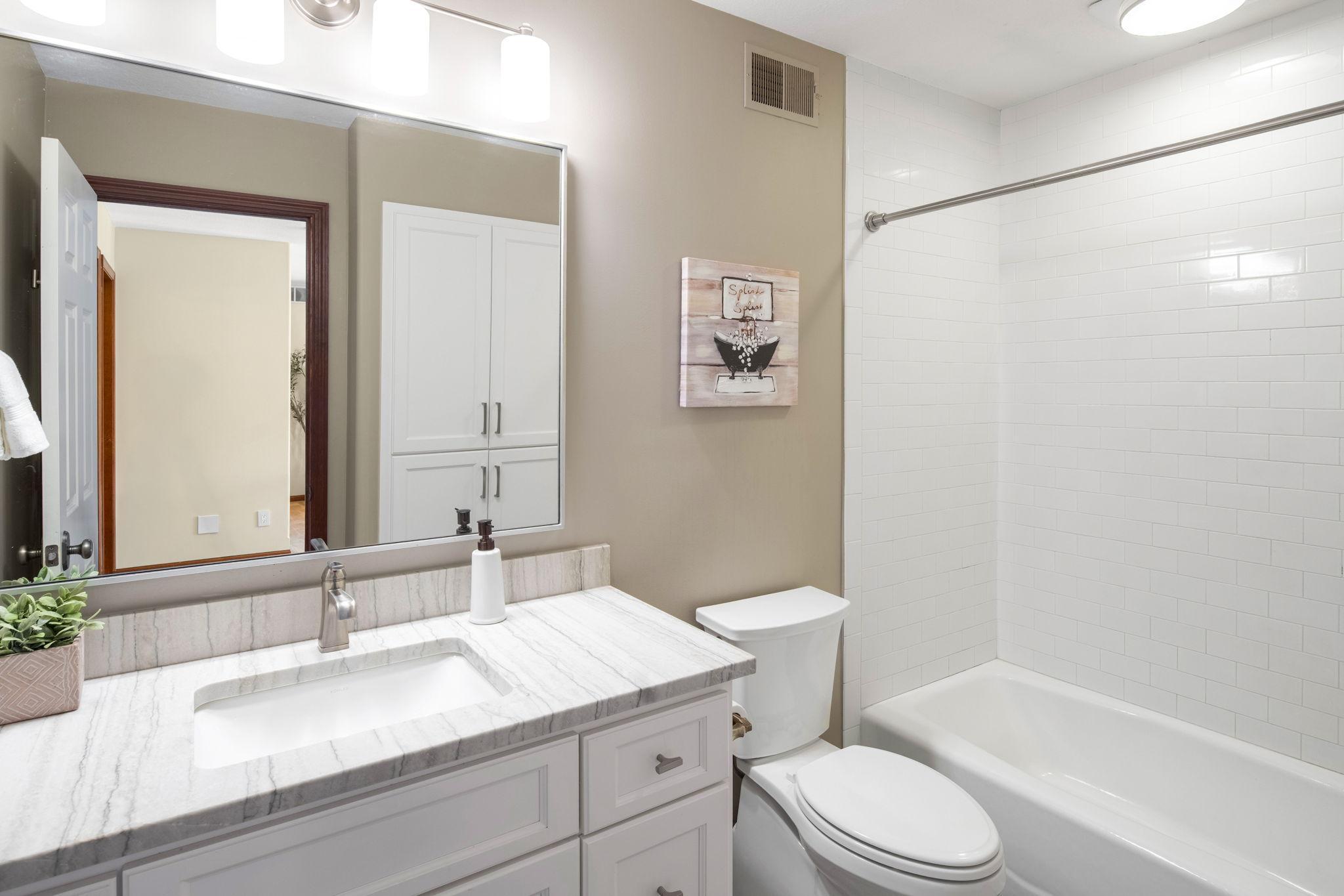 Shared full upper-level bathroom, updated in 2020, featuring a tiled tub/shower.