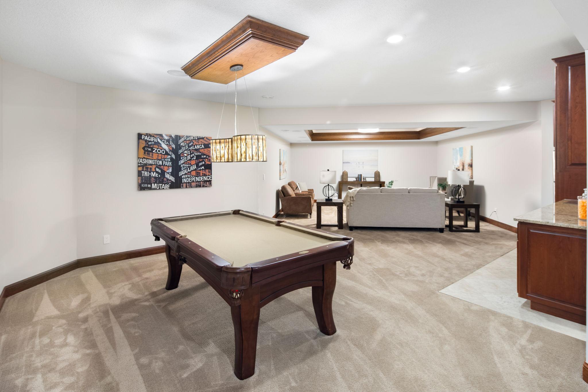Recreation/game area with comfortable finishes and statement lighting.
