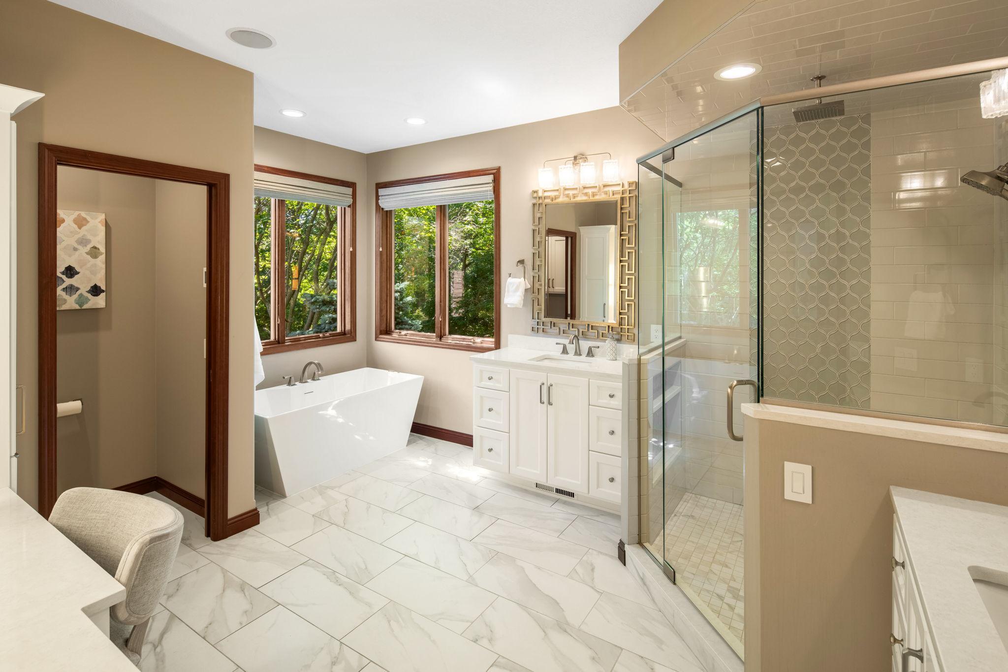 The ensuite bath includes a tiled walk-in rain shower and free-standing tub.