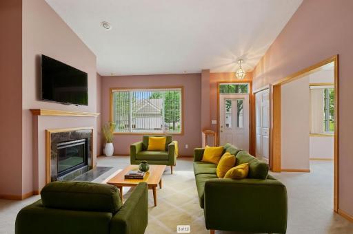 The living room features a fireplace and vaulted ceilings. This photo was virtually staged.