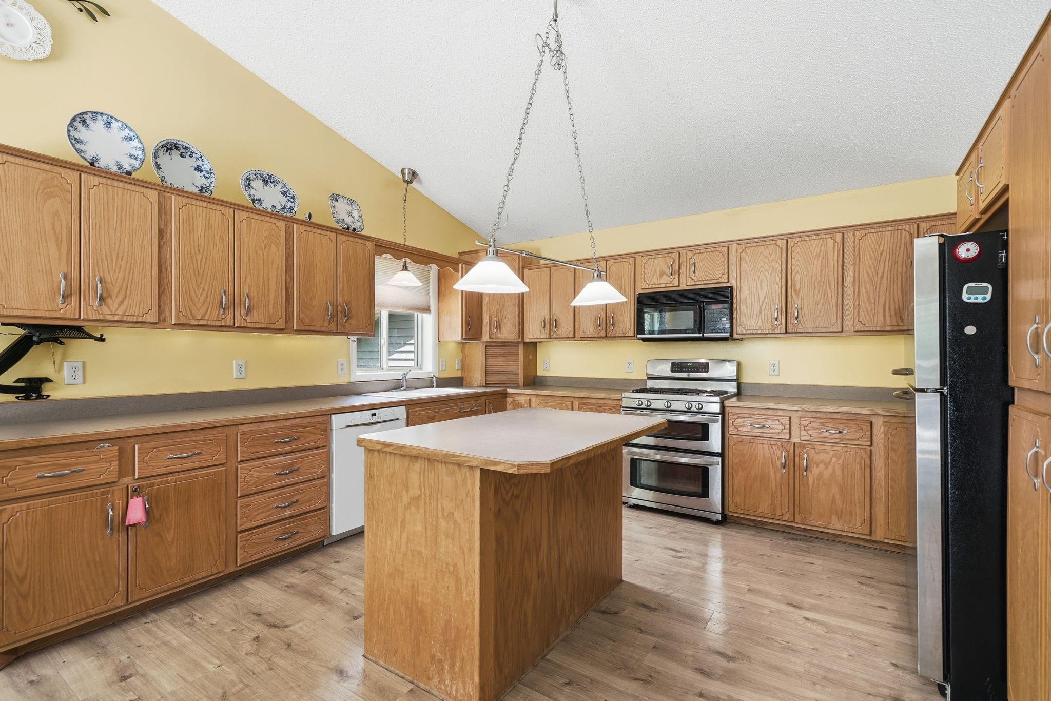 Beautiful kitchen with loads of cabinets, kitchen island and all the feels of home.
