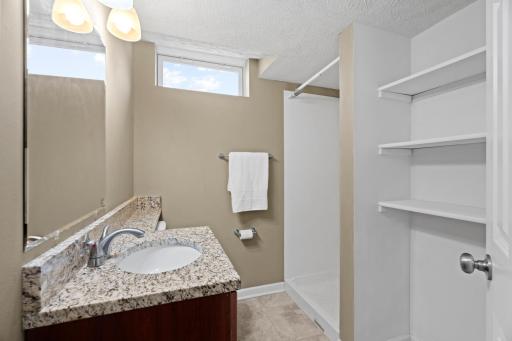Functional secondary full bath at 16860 Foliage Ave W highlighting a granite-look vanity countertop, undermount sink, transom privacy window, and a full bathtub and shower enclosure.