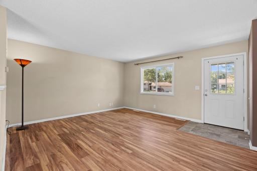 Bright, spacious living area at 16860 Foliage Ave W with neutral interior paint, a large picture window providing abundant natural light, and clean baseboard trim ready for custom furnishings.