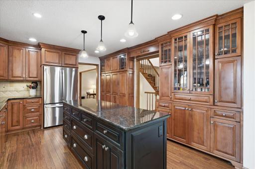 Completely remodeled Kitchen features: beautiful cherry wood cabinets some w/glass faces, pantry space, updated granite counter tops including center island w/pendant lights, tile backsplash, stainless steel appliances