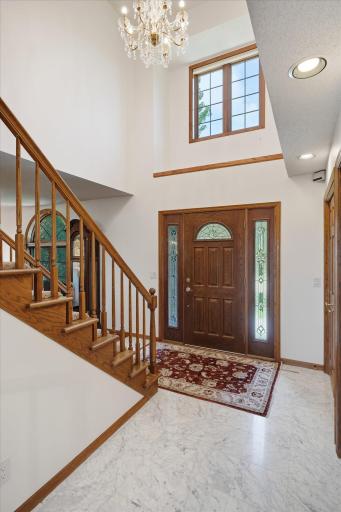 Majestic two story Entry w/marble tile flooring and window above w/matching tile ledge. Beautiful chandelier light fixture and open staircase to above