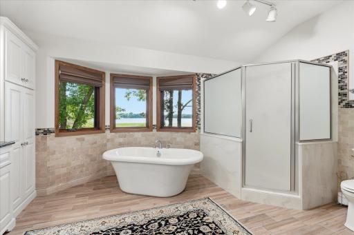 Large walk-in shower w/dual shower/rain heads, tile half walls/backsplash plus tile floors, linen closet and mirrors/light fixtures. Large windows w/up/down blinds provide beautiful lake views