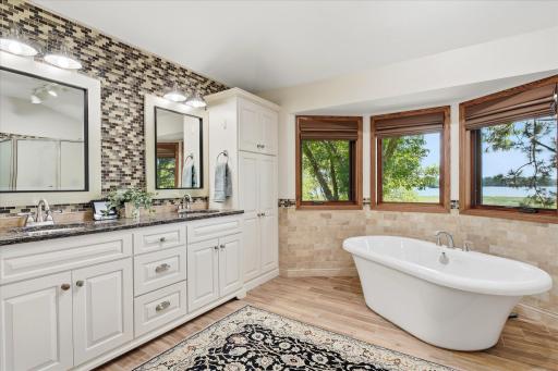 Completely remodeled Upper level Primary bathroom On-Suite features: dual sink white vanity w/beautiful Cambria counter top, quality jetted soaking tub, linen closet. Large windows w/up/down blinds provide beautiful lake views