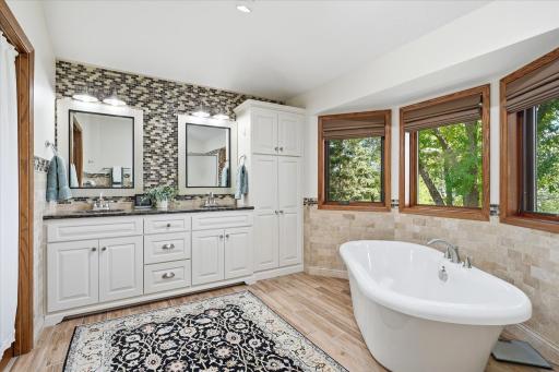 Completely remodeled Primary bathroom On-Suite features: dual sink white vanity w/beautiful Cambria counter top, quality jetted soaking tub, linen closet. Large windows w/up/down blinds provide beautiful lake views