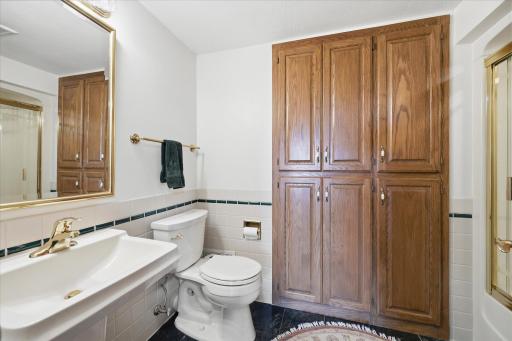 Full Bathroom with tile floor, glass door shower and linen closet.