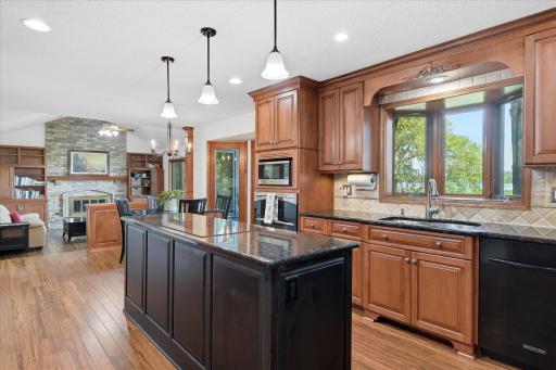 Completely remodeled Kitchen features: beautiful cherry wood cabinets some w/glass faces, pantry space, updated granite counter tops including center island w/pendant lights, tile backsplash, stainless steel appliances