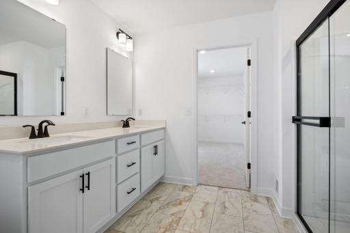 (Photo of a similar home, actual finishes may vary) Dual rectangular undermount sinks and chrome fixtures sit atop the stylish vanity to complement busy lifestyles