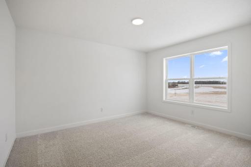 (Photo of a similar home, actual finishes may vary) Three secondary bedrooms are situated down the hall from the owner’s suite on the second floor.