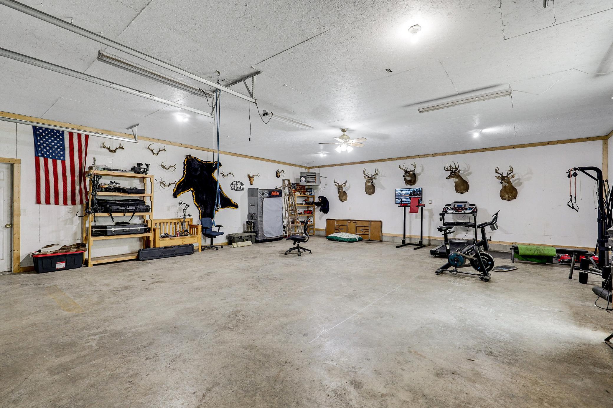 The 34’ by 60’ stick-framed outbuilding with concrete floors and 220V service, is divided in half with a heated workshop on one side, and cold storage on the other. Additional attic storage space spans the entire length of outbuilding.