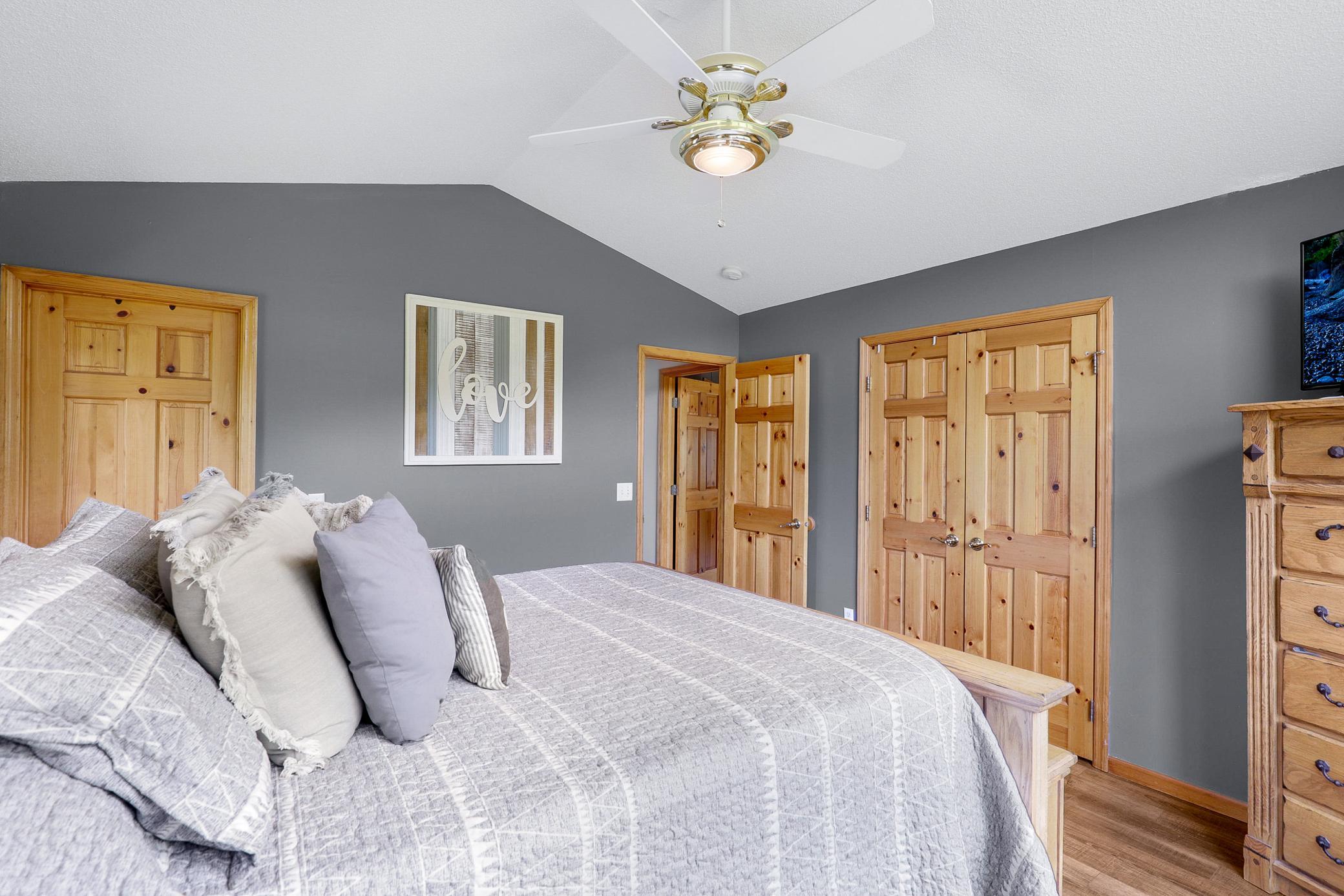 The main level primary bedroom offers vaulted ceilings, peaceful nature views, a wide double door closet, and direct access to the walk-through bathroom, while a second generously sized bedroom features its own walk in closet.