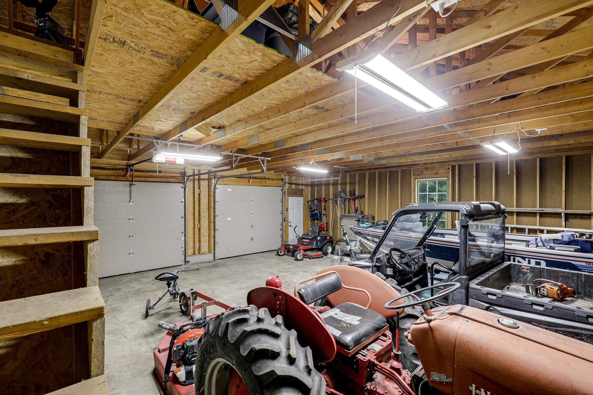 The 34’ by 60’ stick-framed outbuilding with concrete floors and 220V service, is divided in half with a heated workshop on one side, and cold storage on the other. Additional attic storage space spans the entire length of outbuilding.