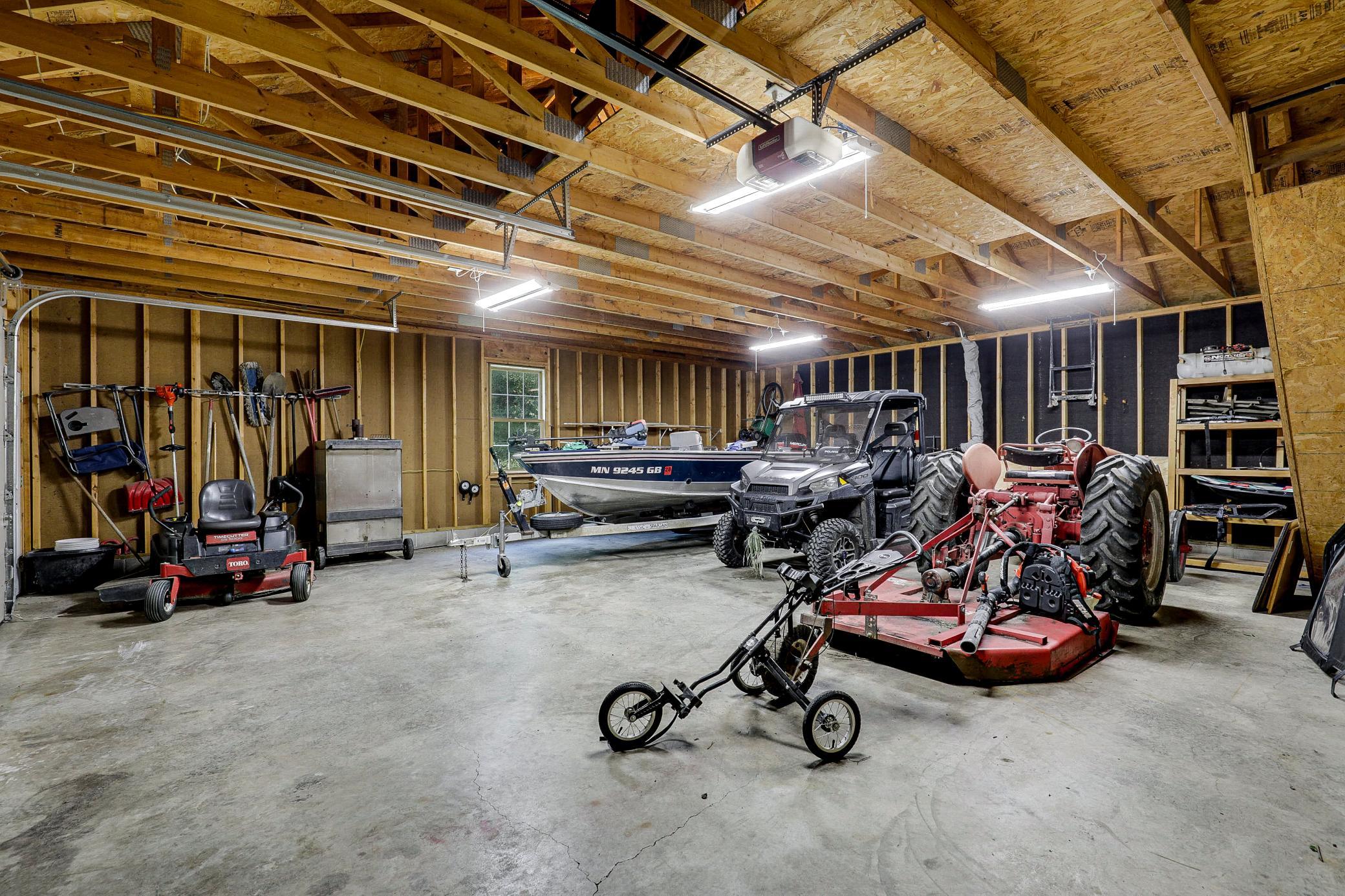 The 34’ by 60’ stick-framed outbuilding with concrete floors and 220V service, is divided in half with a heated workshop on one side, and cold storage on the other. Additional attic storage space spans the entire length of outbuilding.