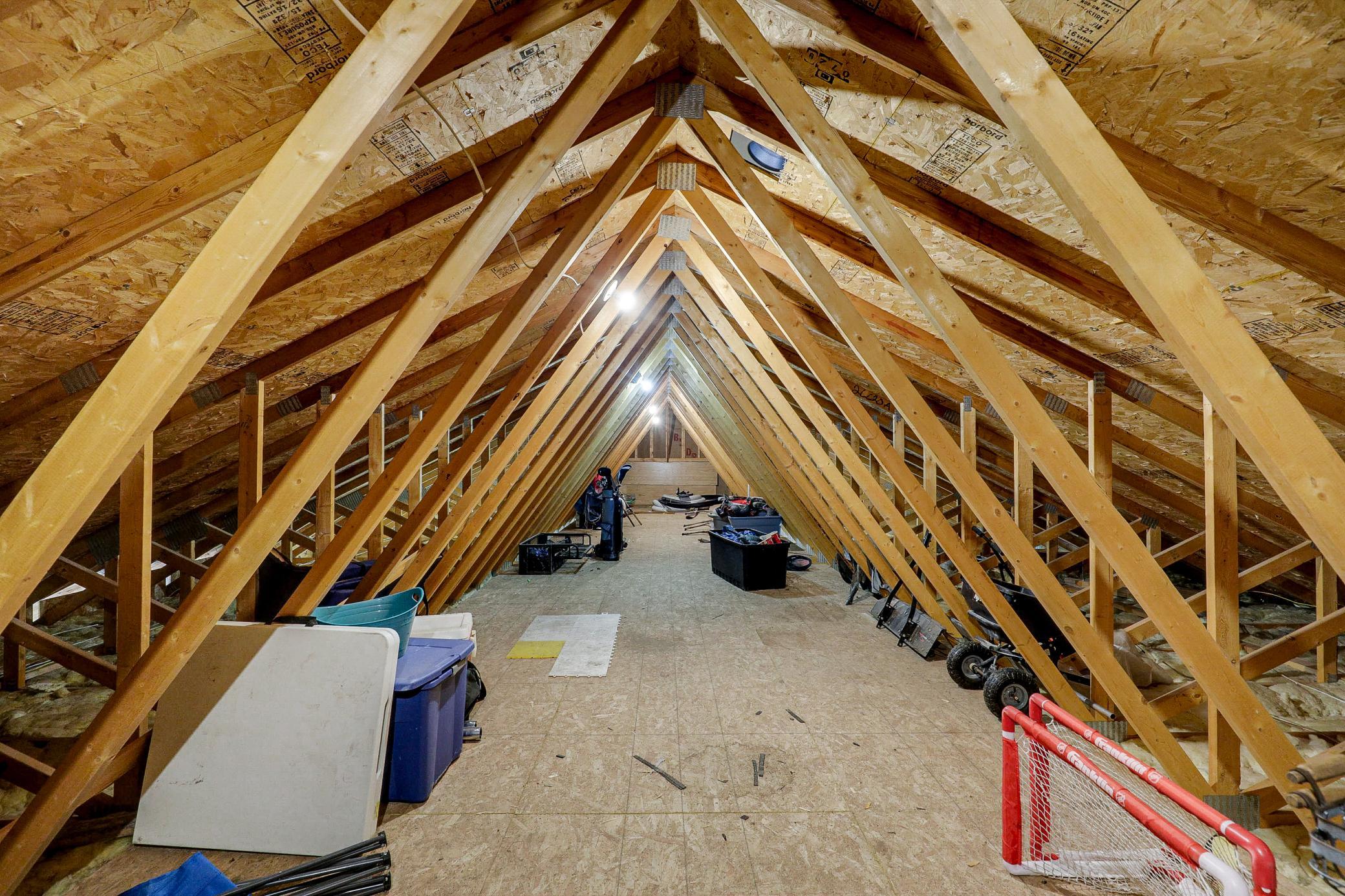 The 34’ by 60’ stick-framed outbuilding with concrete floors and 220V service, is divided in half with a heated workshop on one side, and cold storage on the other. Additional attic storage space spans the entire length of outbuilding.