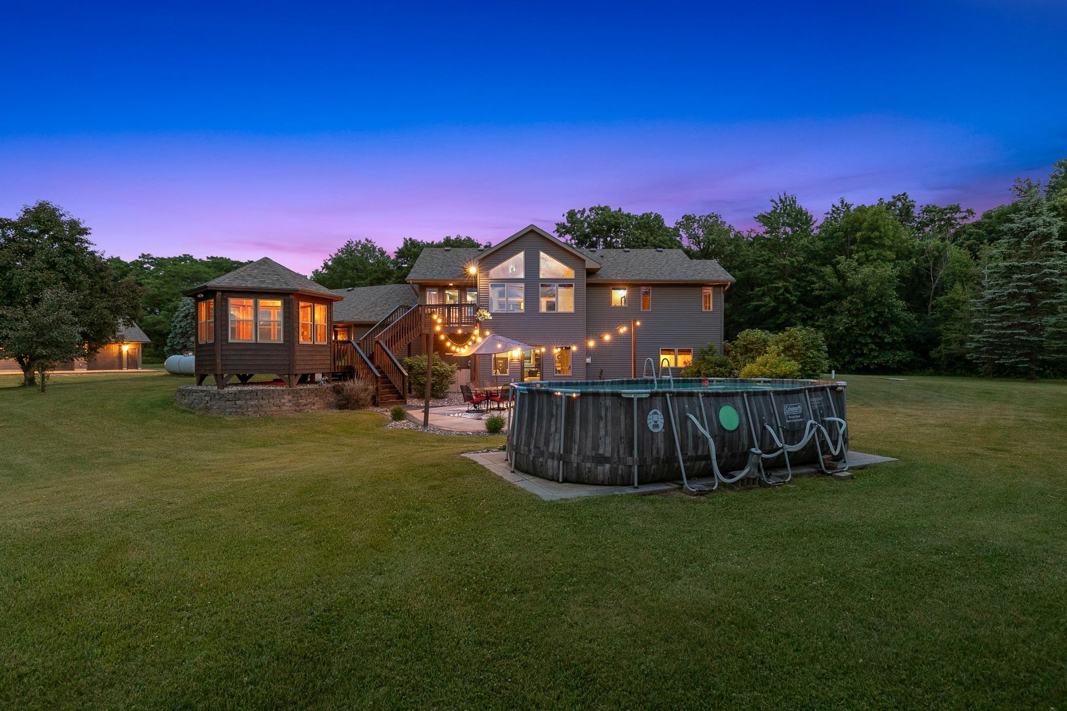 A deck off the main level extends to a gazebo and a large concrete patio, creating an ideal setting for entertaining or unwinding while taking in the peaceful surroundings.