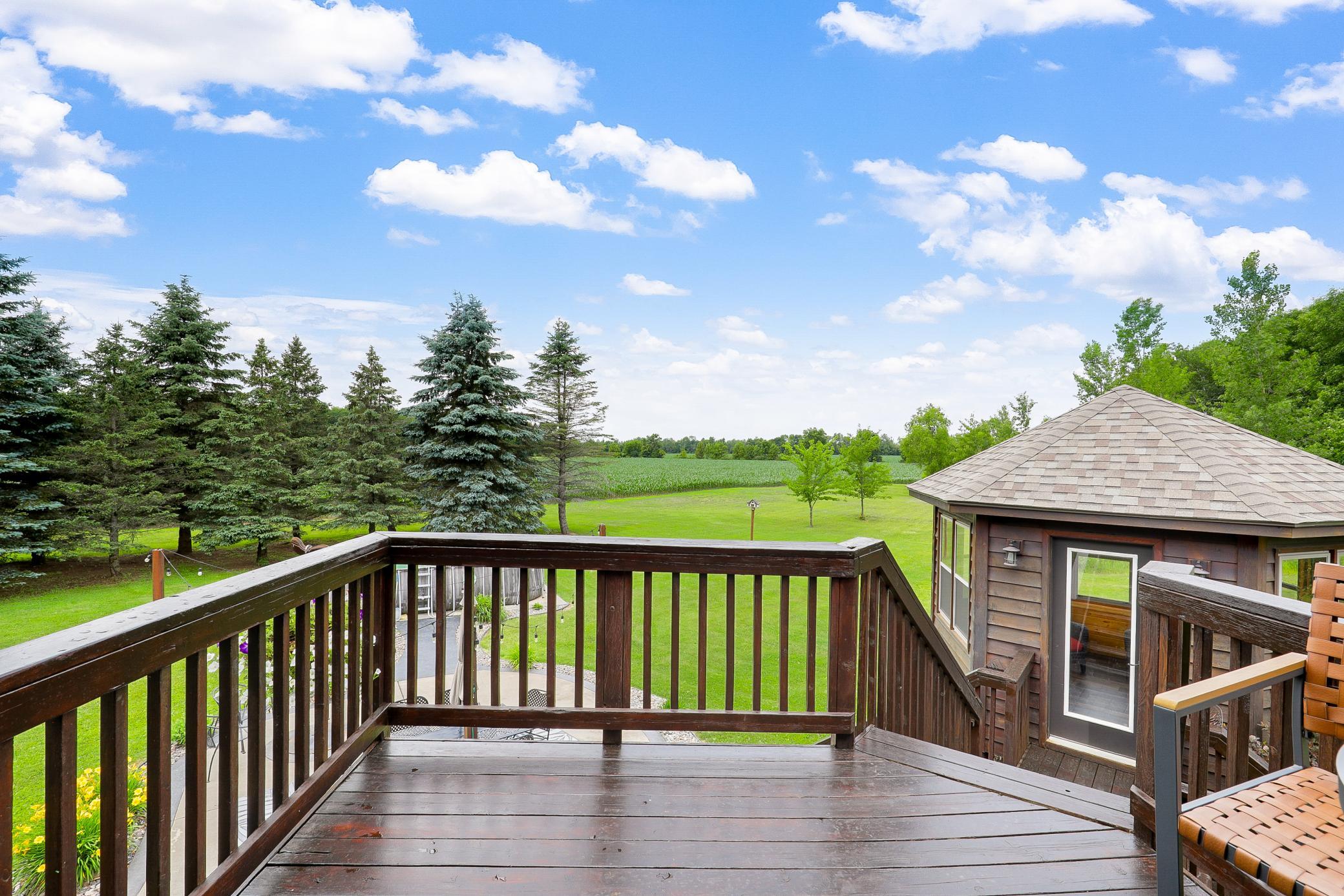 A deck off the main level extends to a gazebo and a large concrete patio, creating an ideal setting for entertaining or unwinding while taking in the peaceful surroundings.