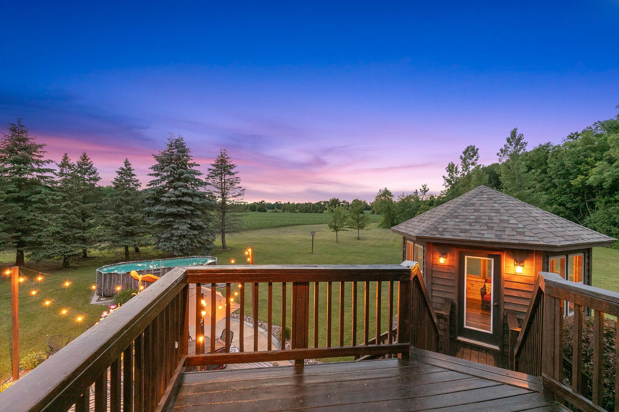 A deck off the main level extends to a gazebo and a large concrete patio, creating an ideal setting for entertaining or unwinding while taking in the peaceful surroundings.