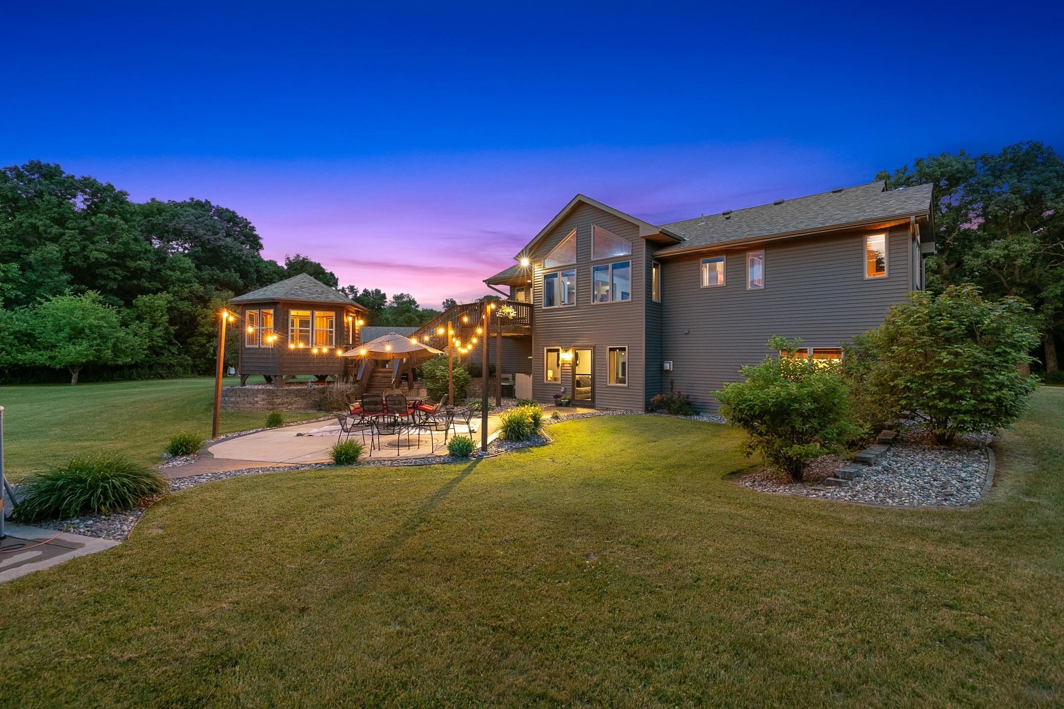 A deck off the main level extends to a gazebo and a large concrete patio, creating an ideal setting for entertaining or unwinding while taking in the peaceful surroundings.