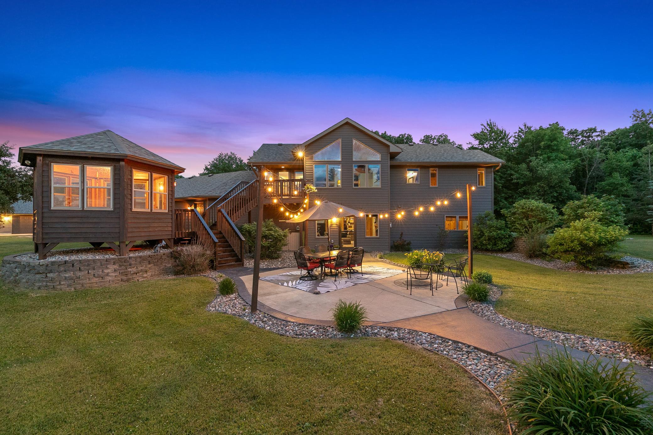 A deck off the main level extends to a gazebo and a large concrete patio, creating an ideal setting for entertaining or unwinding while taking in the peaceful surroundings.