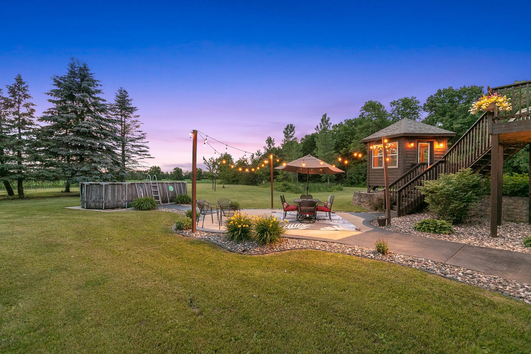 Useful outdoor spaces, including a deck with a gazebo, a large patio, an above-ground pool, and a well-planned food plot for wildlife, create an inviting setting for entertaining and unwinding, integrated with nature.