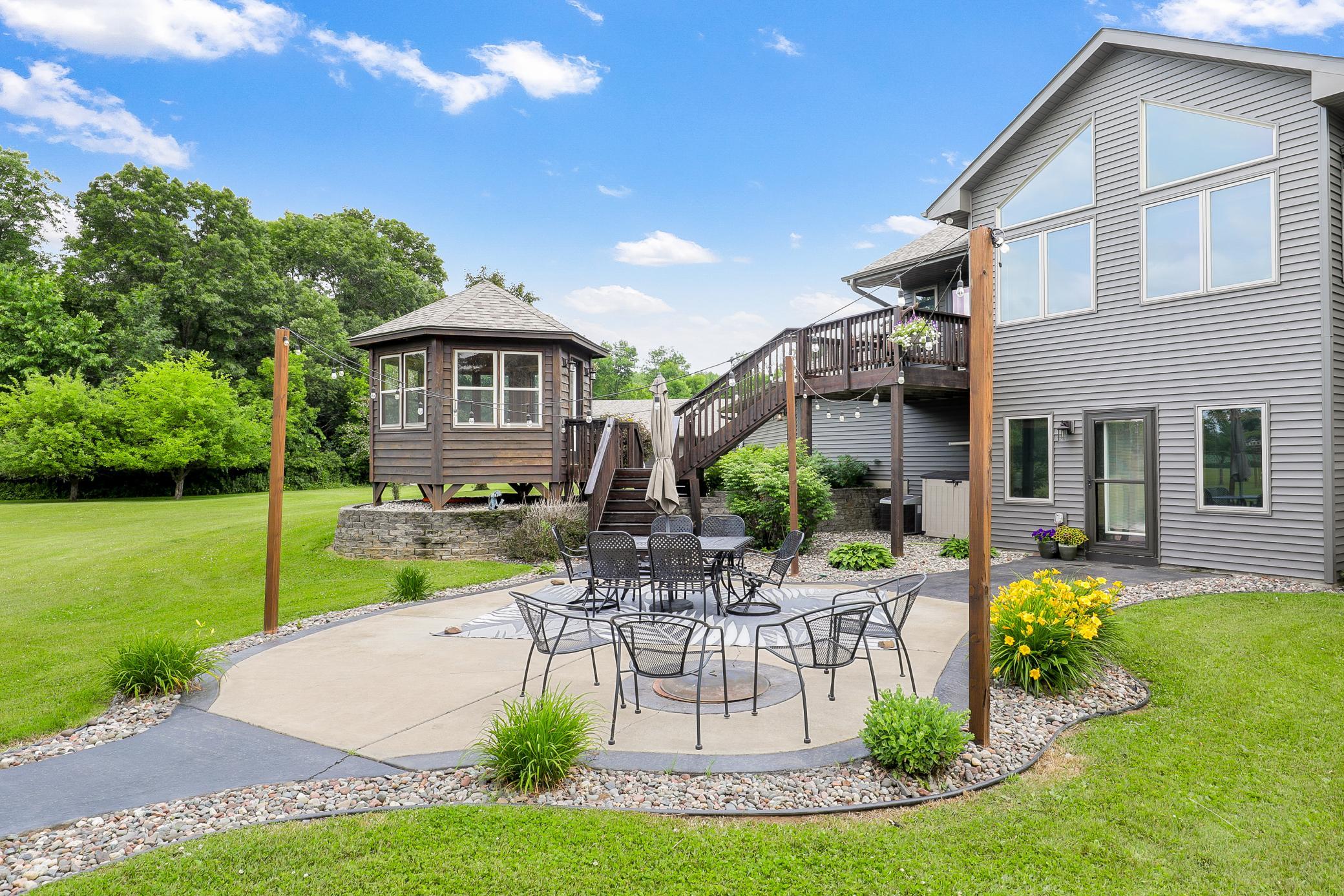 A deck off the main level extends to a gazebo and a large concrete patio, creating an ideal setting for entertaining or unwinding while taking in the peaceful surroundings.