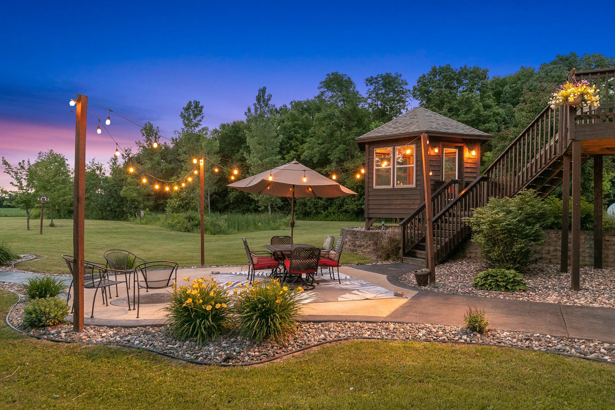 A deck off the main level extends to a gazebo and a large concrete patio, creating an ideal setting for entertaining or unwinding while taking in the peaceful surroundings.
