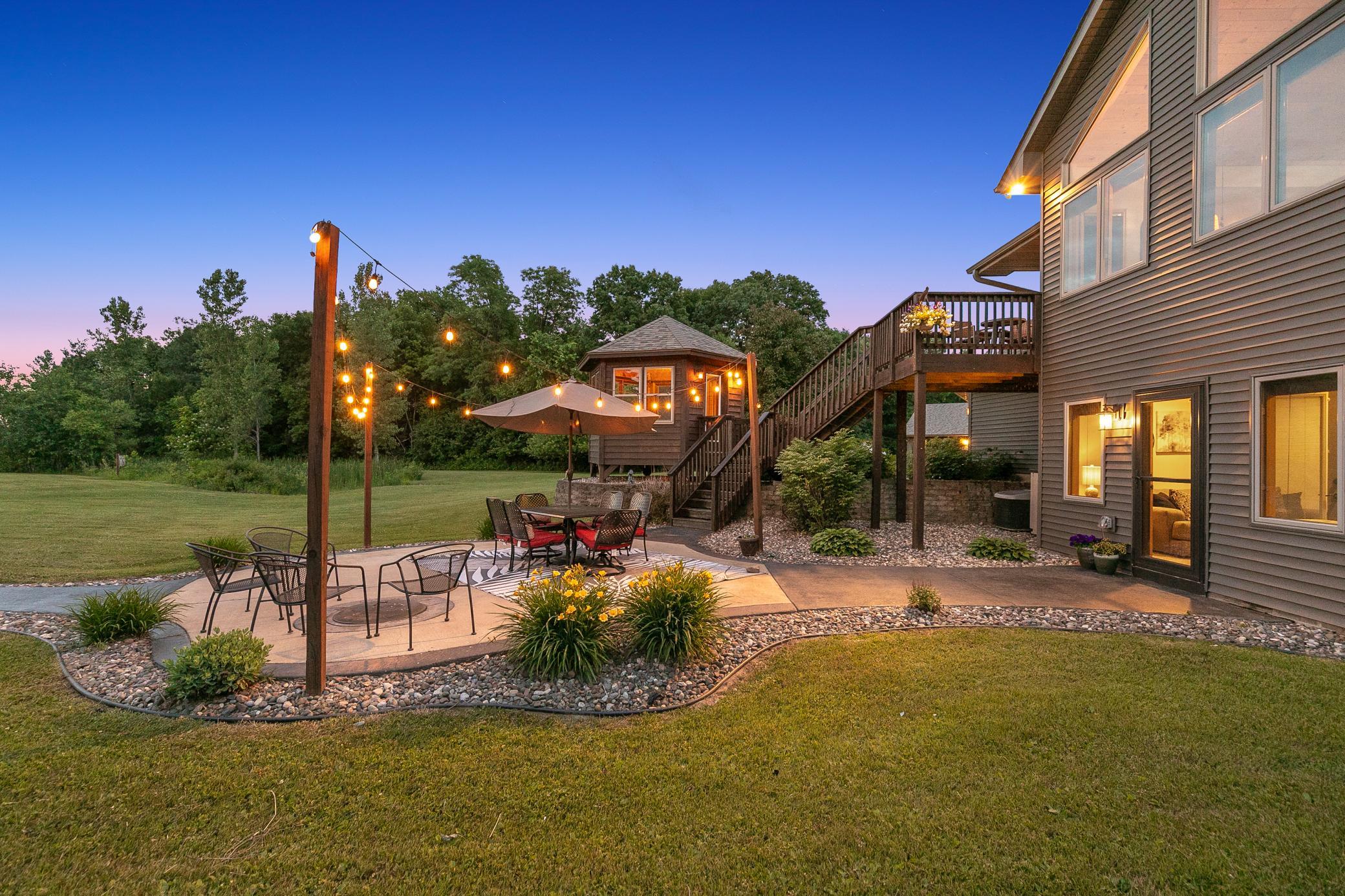 A deck off the main level extends to a gazebo and a large concrete patio, creating an ideal setting for entertaining or unwinding while taking in the peaceful surroundings.