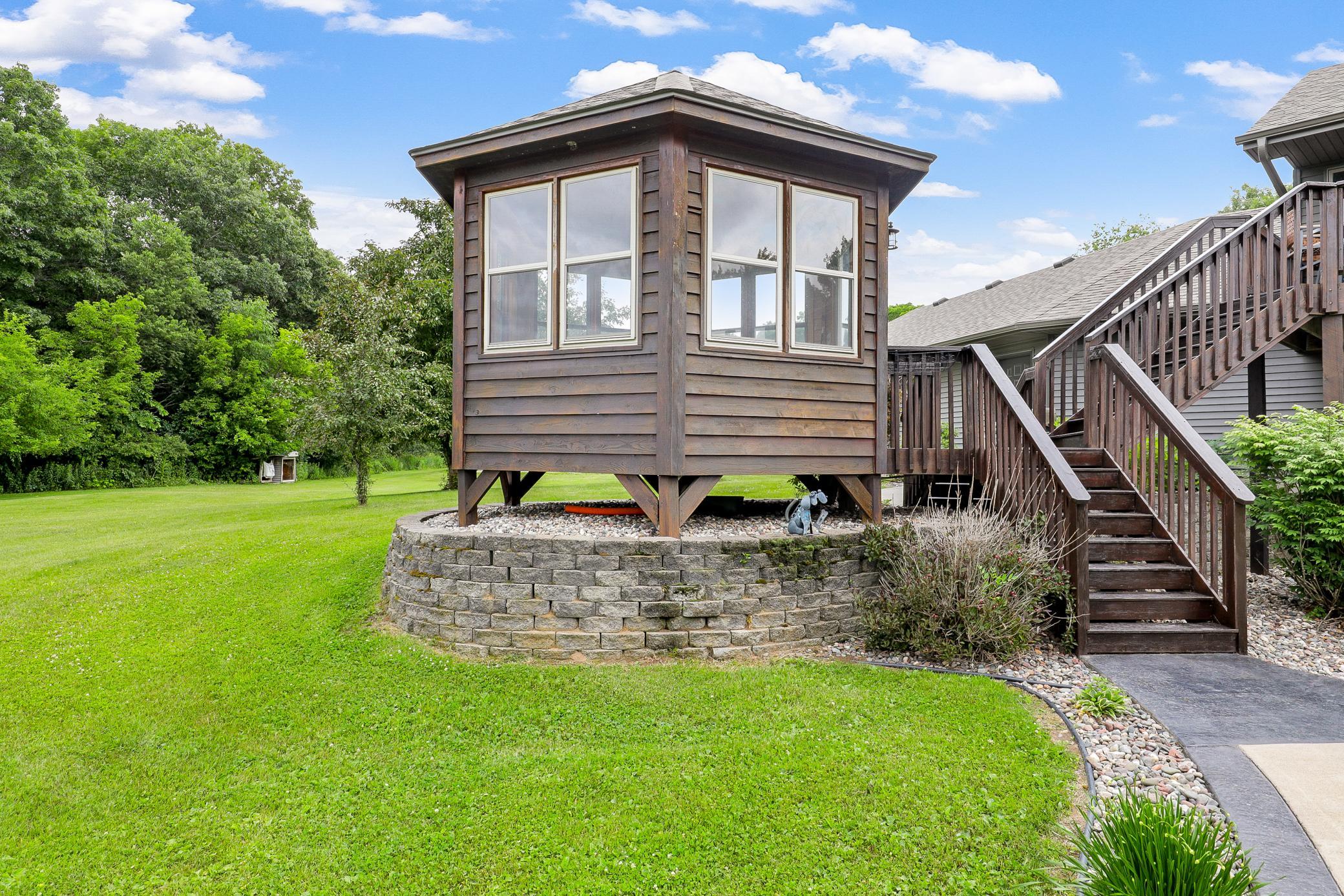 A deck off the main level extends to a gazebo and a large concrete patio, creating an ideal setting for entertaining or unwinding while taking in the peaceful surroundings.