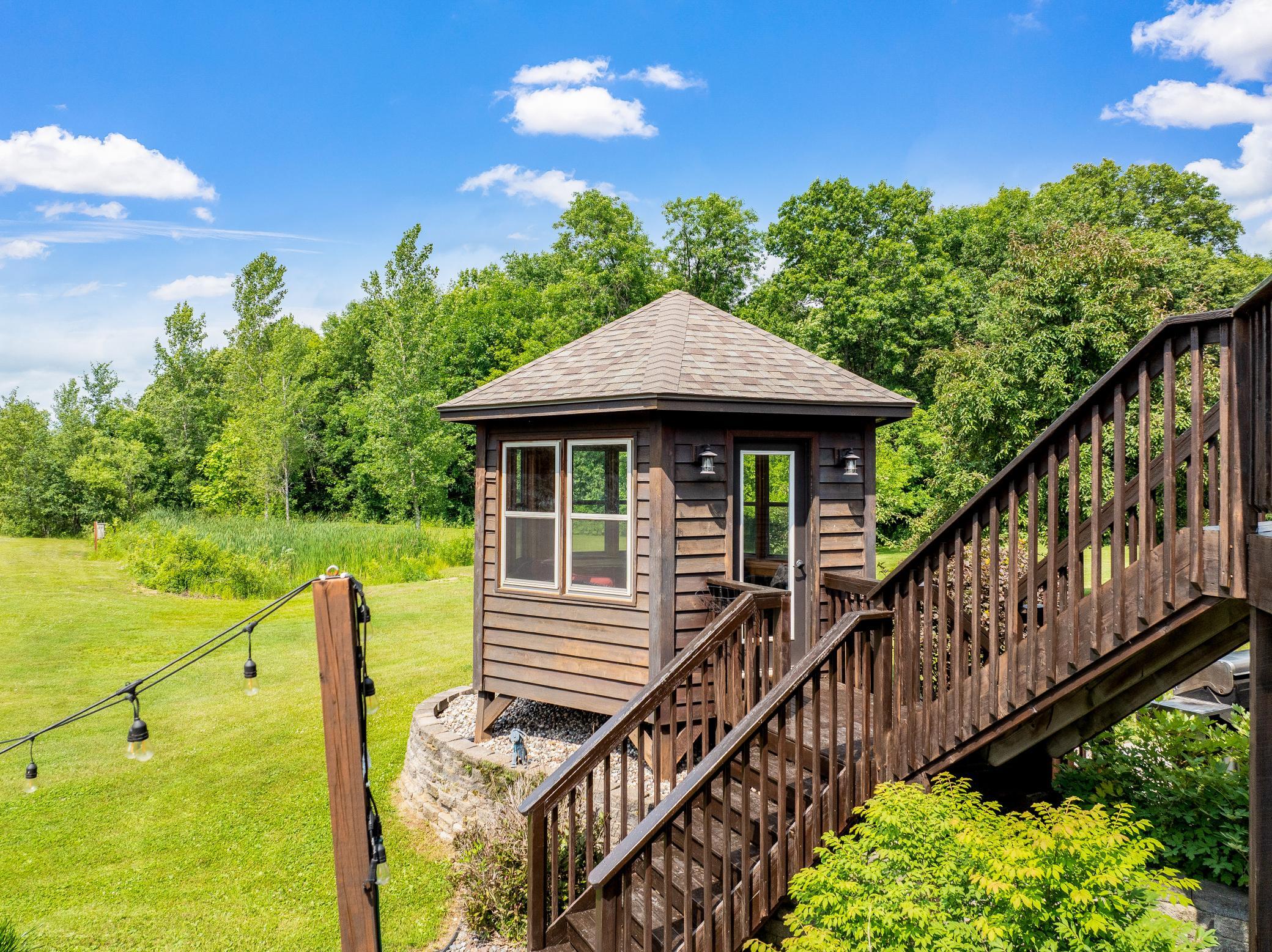 A deck off the main level extends to a gazebo and a large concrete patio, creating an ideal setting for entertaining or unwinding while taking in the peaceful surroundings.