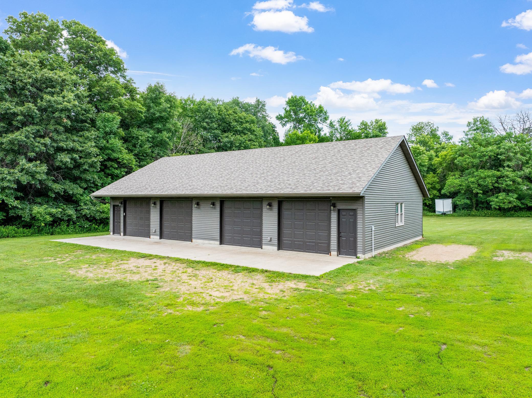 The 34’ by 60’ stick-framed outbuilding with concrete floors and 220V service, is divided in half with a heated workshop on one side, and cold storage on the other. Additional attic storage space spans the entire length of outbuilding.