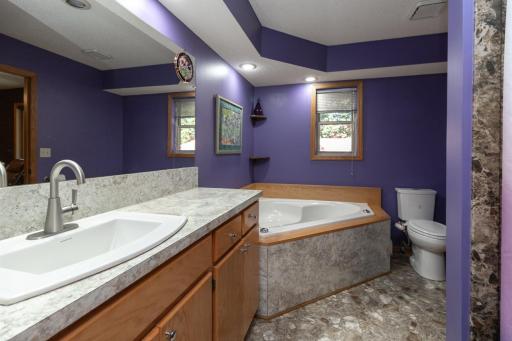 An oversized, jetted tub gives room for a luxurious bath, and an extra large vanity provides ample space for pampering. Shower on right.